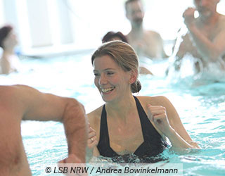 Frau f�hrt eine �bung beim Aquafitness aus