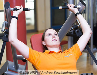 Junge Frau f�hrt eine �bung in einem Fitnessger�t aus