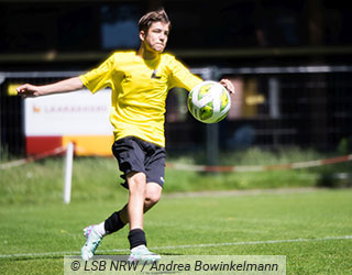 Junger Fu�baller mit Ball auf dem Rasen