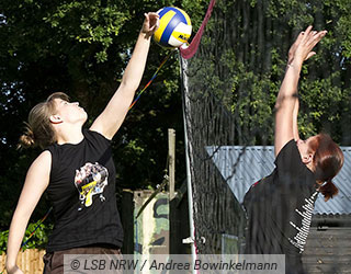 Zwei junge Frauen spielen im Freien Vollyball