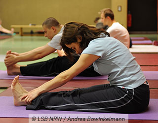 Eine junge Frau f�hrt eine Yogalates �bung aus